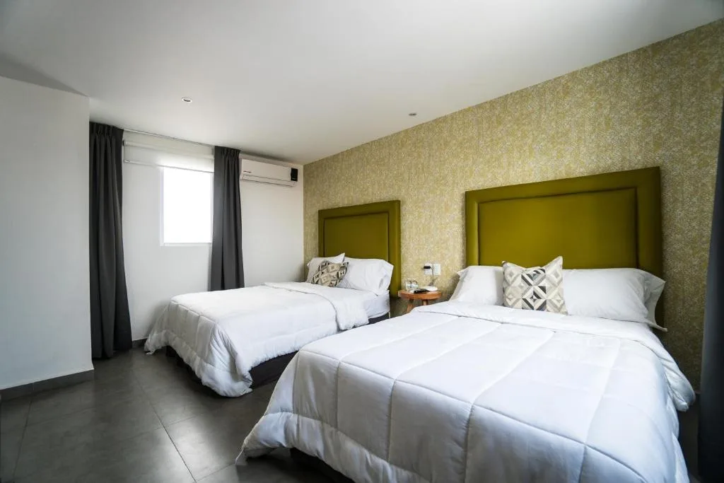 Bright twin guest room at Hotel Suites Regina